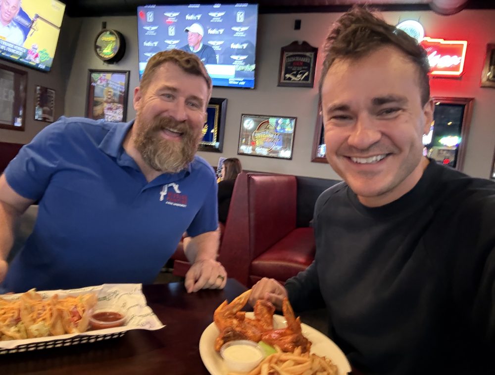 Will at a table with wings and fries